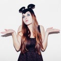 Funny girl represents a small cat or mouse. Woman with a bright makeup hairstyle and night dress mouse ears having fun. On white Royalty Free Stock Photo