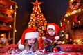 Funny girl in Santa hat writes letter to Santa and her liitle brother Royalty Free Stock Photo