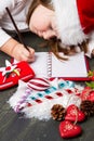 Funny girl in Santa hat writes letter to Santa near christmas decoration Royalty Free Stock Photo