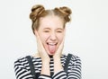 Funny girl showing her tongue while posing against studio background