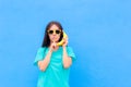 Funny Girl with Sunglasses and Banana Phone on Blue Background Royalty Free Stock Photo