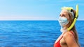 Funny girl in surgical face mask on sea beach