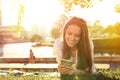 Funny girl using a smartphone on the grass of a park with a green background Royalty Free Stock Photo