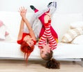 Funny girlfriends in playful mood lying on sofa