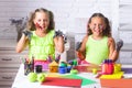 Funny girls children painters painting with gouache paints on table. Happy smiling kids with colored hands. Arts and Royalty Free Stock Photo