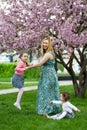 Funny girls walking on the lawn with her mother. Sisters play together with mom. maternal care. happy family