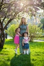 Funny girls walking on the lawn with her mother. Sisters play together with mom. maternal care. happy family