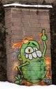 Funny green cartoon graffiti showing the finger, on brick wall in Salzburg Royalty Free Stock Photo