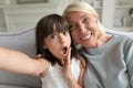 Grandmother and granddaughter holding camera taking self-portrait webcam view