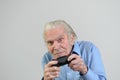 Funny grandfather playing a video game on console Royalty Free Stock Photo