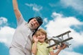 Funny grandfather and son playing with wooden plane against summer sky background. Child boy with dreams of flying or