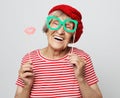 Funny grandmother wearing red clothes holding falce glasses and ready for party