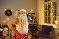 Funny granddad with Santa beard, headphones and boombox having fun on Christmas night at home