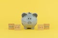 Funny gray piggy bank on yellow background