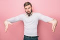 Funny guy is dansing with the closepins in his beard. H makes funny faces. Isolated on pink background. Royalty Free Stock Photo