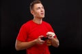 A funny guy squinting and showing the language holding a game joystick and popcorn. On a black background.