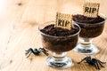 Funny Halloween chocolate mousse with tomb cookie and spiders on wood