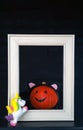 Funny Halloween. Pumpkin baby in white frame and with unicorn on the black background. Halloween concept with copy space.