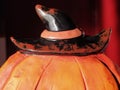 Funny Halloween pumpkin with black hat. Bright orange ceramic pumpkin. All Saints` Day. Copy space. Soft focus. Postcard Royalty Free Stock Photo