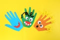 Funny hand shaped monsters on yellow background, flat lay. Halloween decoration Royalty Free Stock Photo