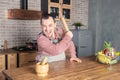 Funny handsome screaming angry man wearing pinafore with rolling pin