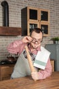 Funny smiling man wearing pinafore with towel and eyeglasses on the kitchen