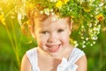 funny happy baby child girl in a wreath on nature laughing in summer Royalty Free Stock Photo