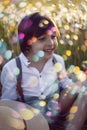 funny happy a beautiful boy child sit in hat on a field with white dandelions at sunset in summer. soap bubbles are Royalty Free Stock Photo