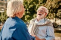 So funny! Happy and beautiful elderly couple holding hands and laughing while standing outdoors Royalty Free Stock Photo