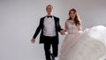 Funny and happy bride and groom, dance and jump with happiness, married. Studio portrait, light background Royalty Free Stock Photo