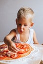 Happy chef boy cooking pizza