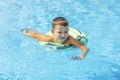 Funny happy child boy in swiming pool on inflatable rubber circle ring. Kid playing in pool. Summer holidays and vacation concept Royalty Free Stock Photo
