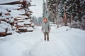 Funny happy child girl portrait on the walk in winter snowy forest with tree felling on background Royalty Free Stock Photo