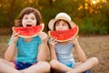 Funny happy children eating watermelon in park at sunset Royalty Free Stock Photo