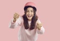 Funny happy excited young woman in pink helmet pretending to drive invisible car