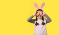 Funny happy girl with Easter bunny ears and colorful Easter eggs on a yellow background. Happy Easter! Copy space. Banner Royalty Free Stock Photo