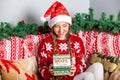 Funny Happy Girl in Santa Claus Hat Opens Christmas Gift Box With Present Inside Royalty Free Stock Photo