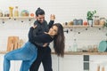 Funny happy good-looking young couple smiling and dancing in their new bright kitchen. Royalty Free Stock Photo