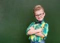 Funny happy nerd near empty green chalkboard Royalty Free Stock Photo