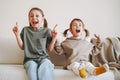 Funny happy two children girls sisters having fun on couch at the home Royalty Free Stock Photo