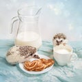 Funny hedgehogs near a mug of milk