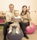 Funny hipster family jumping on fitness balls in playroom Royalty Free Stock Photo