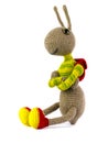 Funny homemade knitted ant with a backpack on a white background