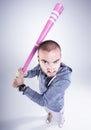 Funny hooligan with a pink baseball bat looking angry in the studio Royalty Free Stock Photo