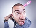 Funny hooligan with a pink baseball bat screaming in the studio Royalty Free Stock Photo