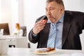 Funny hungry office worker gobbling doughnuts