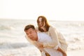 Funny husband and wife on beach. man cannot raise woman, she weighs lot Royalty Free Stock Photo