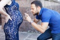 Funny image. Man photographing pregnant belly on the phone. Royalty Free Stock Photo