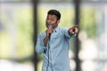 Funny indian man entertainer talking into microphone and pointing with index finger. Royalty Free Stock Photo