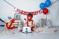 Funny infant baby boy tasting his 1st birthday cake Royalty Free Stock Photo